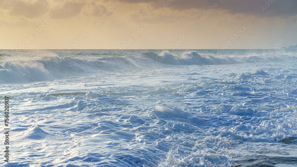 Obraz premium Alanya, Antalya, Türkiye, Turkey, Panoramic view of the storm, large waves with sea foam rolling onto the beach, at sunset, the Mediterranean Sea