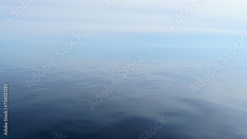 Republic of Karelia, Russia, Lake Ladoga, Panoramic view of the lake surface during calm, mirrored water, cloudy sky, at daytime
