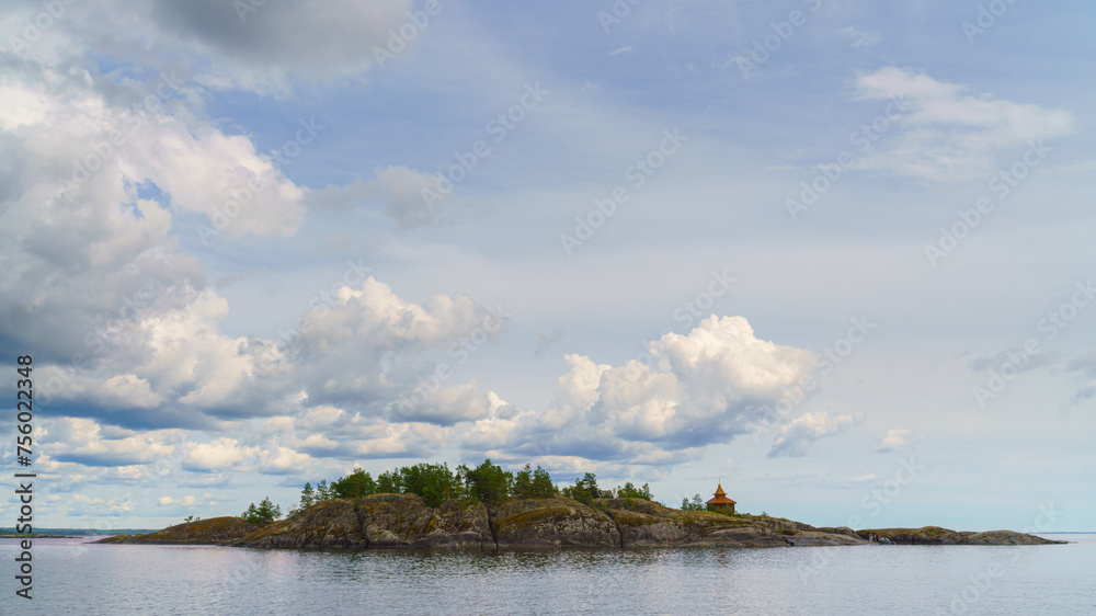 Republic of Karelia, Russia, Panoramic view of an island in the middle of Lake Ladoga, mirrored water, cloudy sky, at daytime