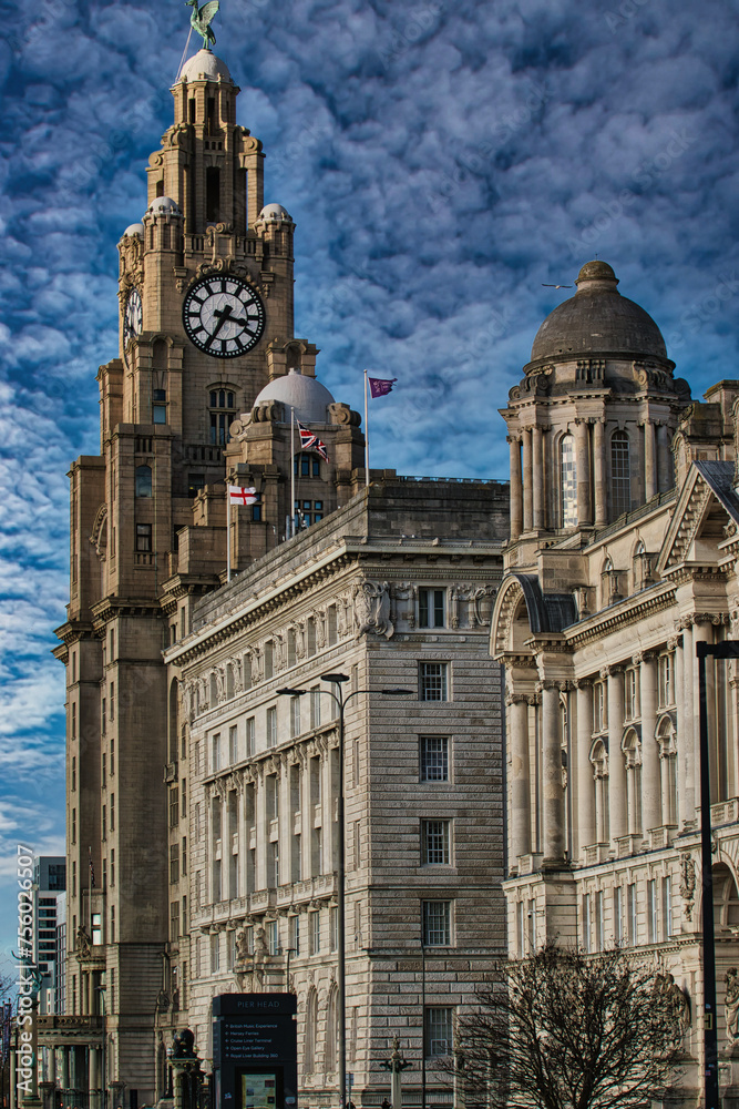 Historic Liver Building in Liverpool with clock tower under a cloudy sky, iconic architecture.