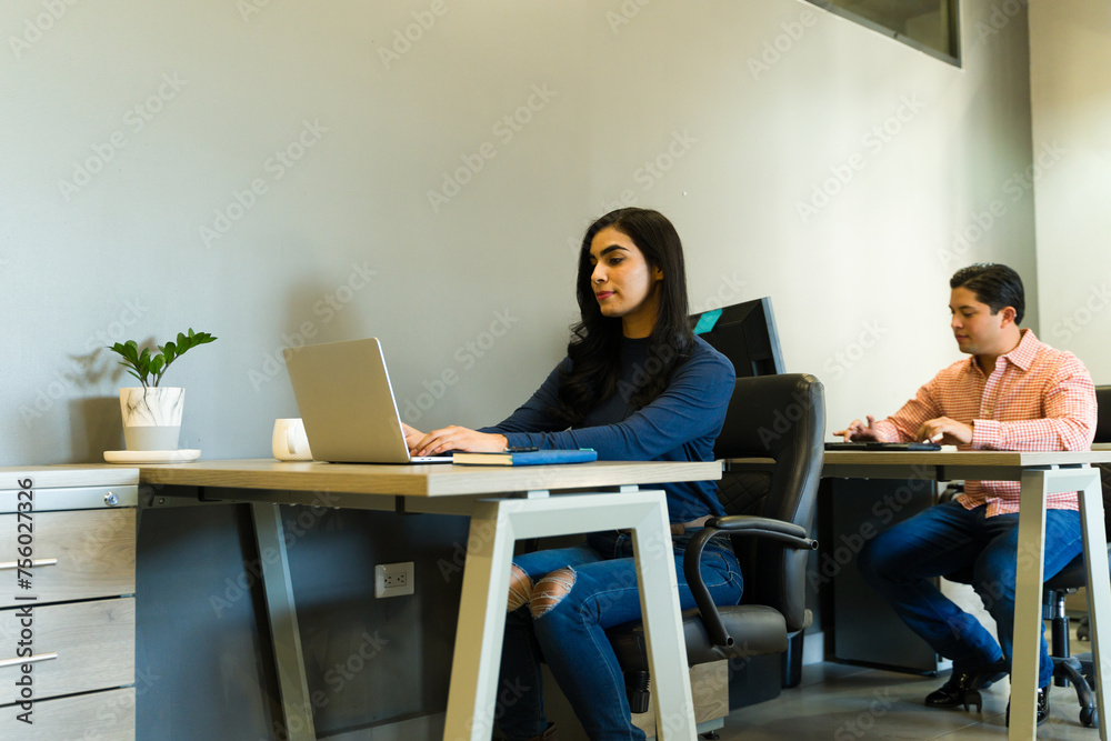 Businesspeople using computers for work in an open plan office Businesspeople using computers for work in an open plan office