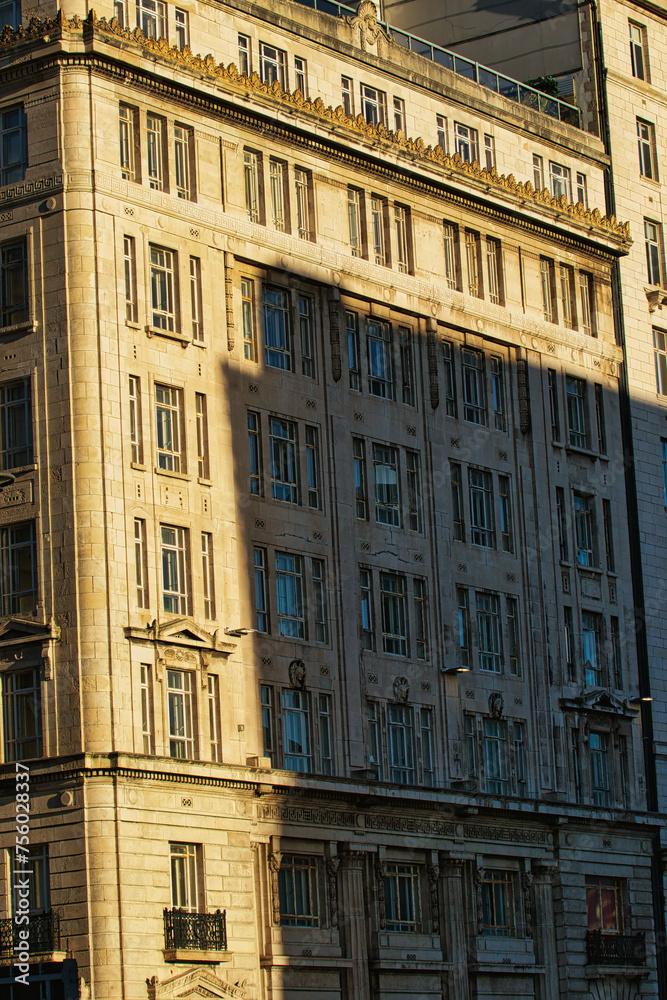 Sunlight casting shadows on a classic urban building facade during golden hour, highlighting architectural details in Liverpool, UK.
