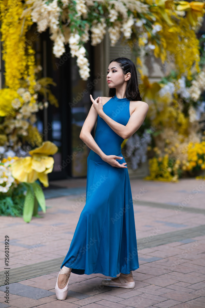 Beautiful Asian ballerina posing against the backdrop of a building decorated with flowers. Vertical photo Beautiful Asian ballerina posing against the backdrop of a building decorated with flowers. Vertical photo