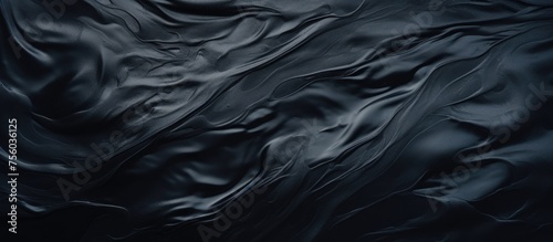 A close up of a black marble texture resembling a liquid wave, with electric blue patterns flowing through it like wind in darkness. The transparent material looks silky and rocklike