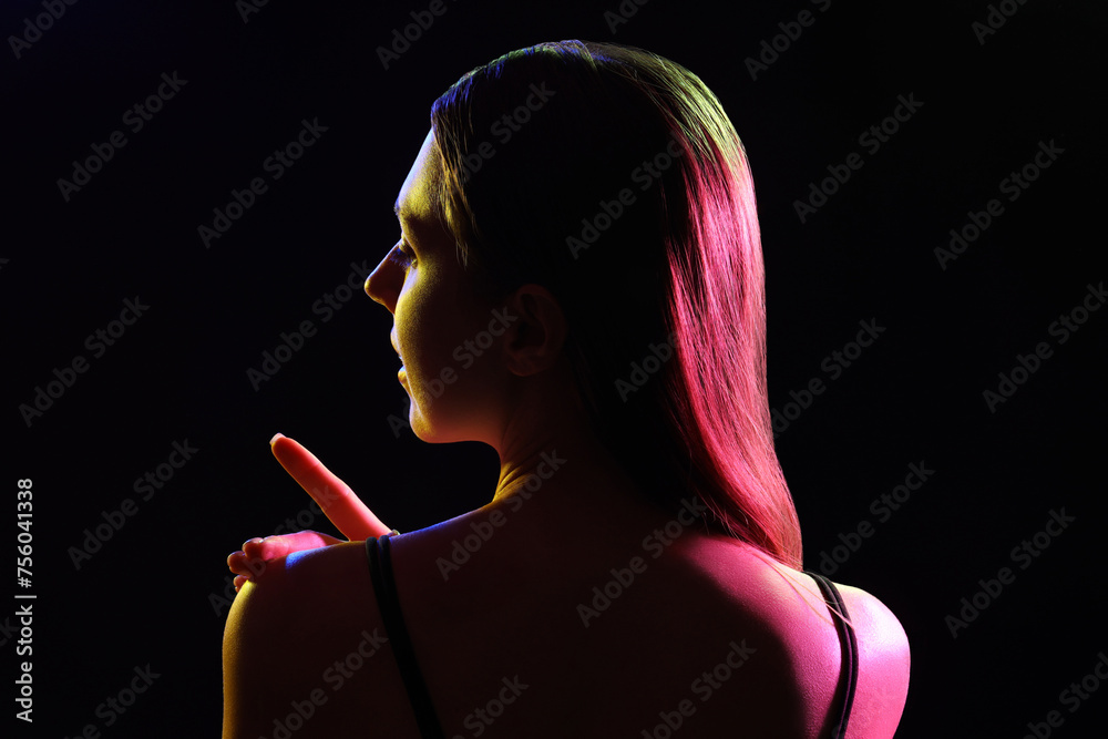 Obraz premium Silhouette of young woman on dark background, back view