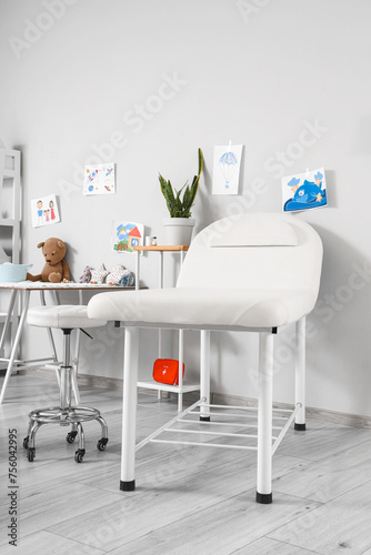 Interior of pediatrician's office with couch and children's drawings © Pixel-Shot