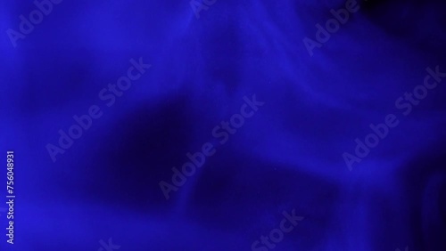 Dynamic blue smoke moves with fluidity against a dark background 4K footage.