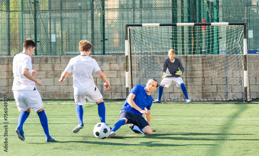 Fototapeta premium Teens playing soccer football match. Competition between two youth soccer teams. Football soccer tournament