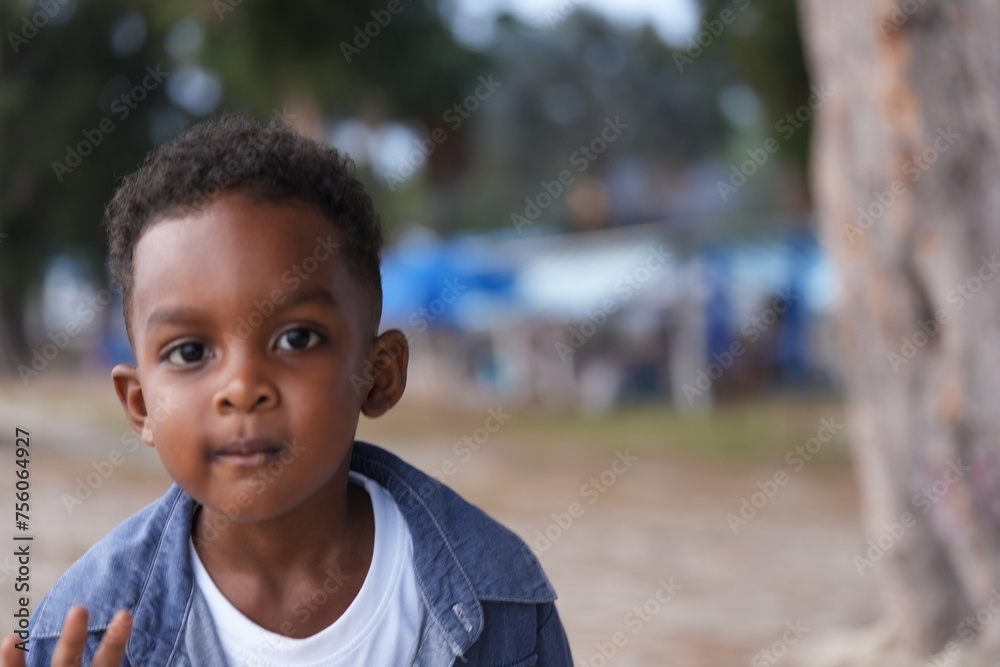 Mixed race African and Asian boy is playing at the outdoor area. smiling happy boy has fun running on the beach. portrait of boy lifestyle with a unique hairstyle. Mixed race African and Asian boy is playing at the outdoor area. smiling happy boy has fun running on the beach. portrait of boy lifestyle with a unique hairstyle.