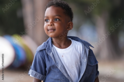 Mixed race African and Asian boy is playing at the outdoor area. smiling happy boy has fun running on the beach. portrait of boy lifestyle with a unique hairstyle.