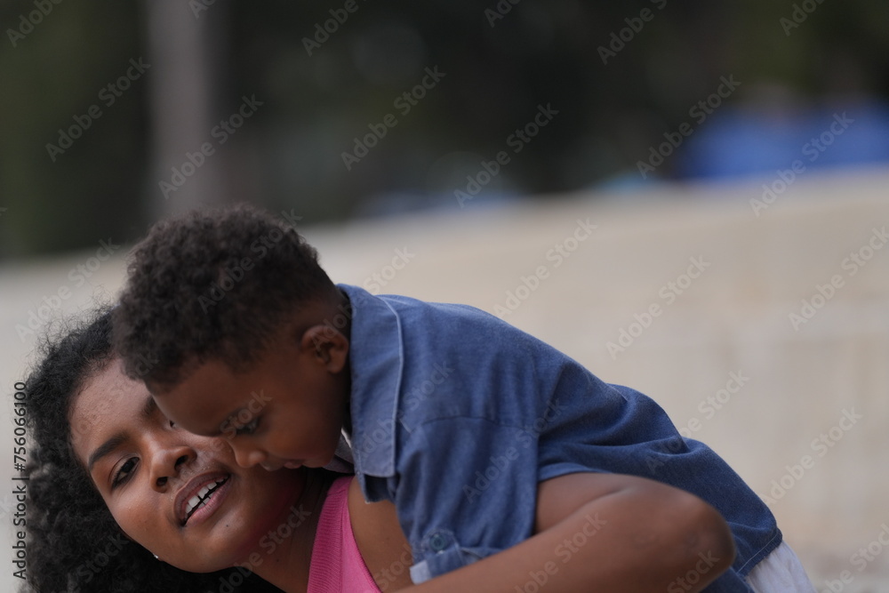 Mixed race African and Asian mother and boy is playing at the outdoor area. smiling happy family have fun running on the beach. portrait of mom and kid lifestyle with a unique hairstyle. Mixed race African and Asian mother and boy is playing at the outdoor area. smiling happy family have fun running on the beach. portrait of mom and kid lifestyle with a unique hairstyle.
