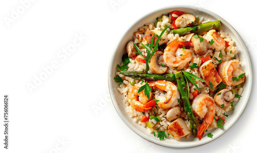 Top view of risotto, rice with shrimp, asparagus and vegetables in a round bowl. Concept of healthy eating, sea food, Italian cuisine. Isolated on a white background. Copy space for text, advertising