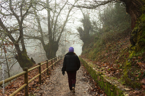 Unrecognizable young woman walking on a foggy winter day in Las Medulas, Leon.