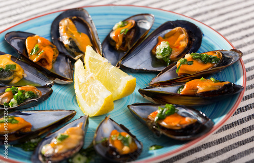 Plate with mediterranean seafood dish black shell mussels with herbs