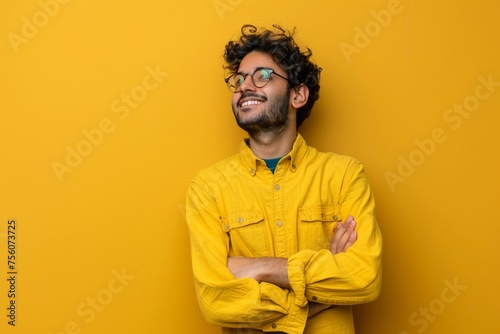 Happy joyful smiling young indian man looking aside up thinking of new good opportunities, dreaming, feeling inspired and proud standing isolated on yellow background. Portrait © Ahtesham