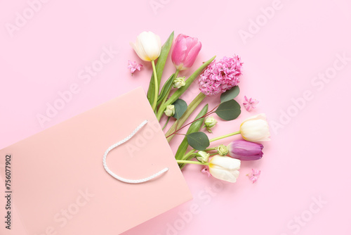 Paper shopping bag with flowers on pink background
