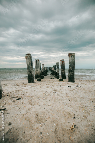 sea wallpaper. Old destroyed wooden pier in the sea on a cloudy day. Wadden Sea Coast and wooden pillars .Low tide time.