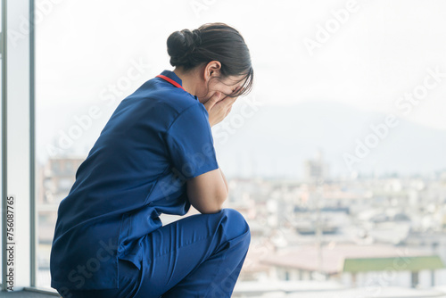 病院で泣く女性看護師・ナース・医師・介護士（医療ミス・看取り・悲しい・ハラスメント）
 photo
