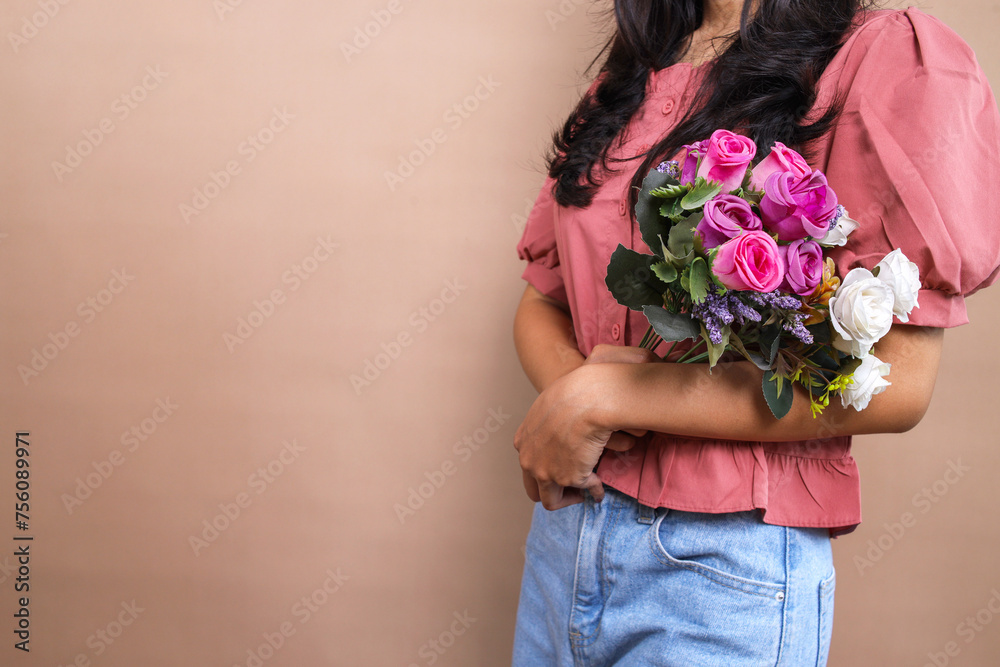 Cropped image of woman holding bouquet of flowers over beige background with copy space, International Women`'s Day concept Cropped image of woman holding bouquet of flowers over beige background with copy space, International Women`'s Day concept