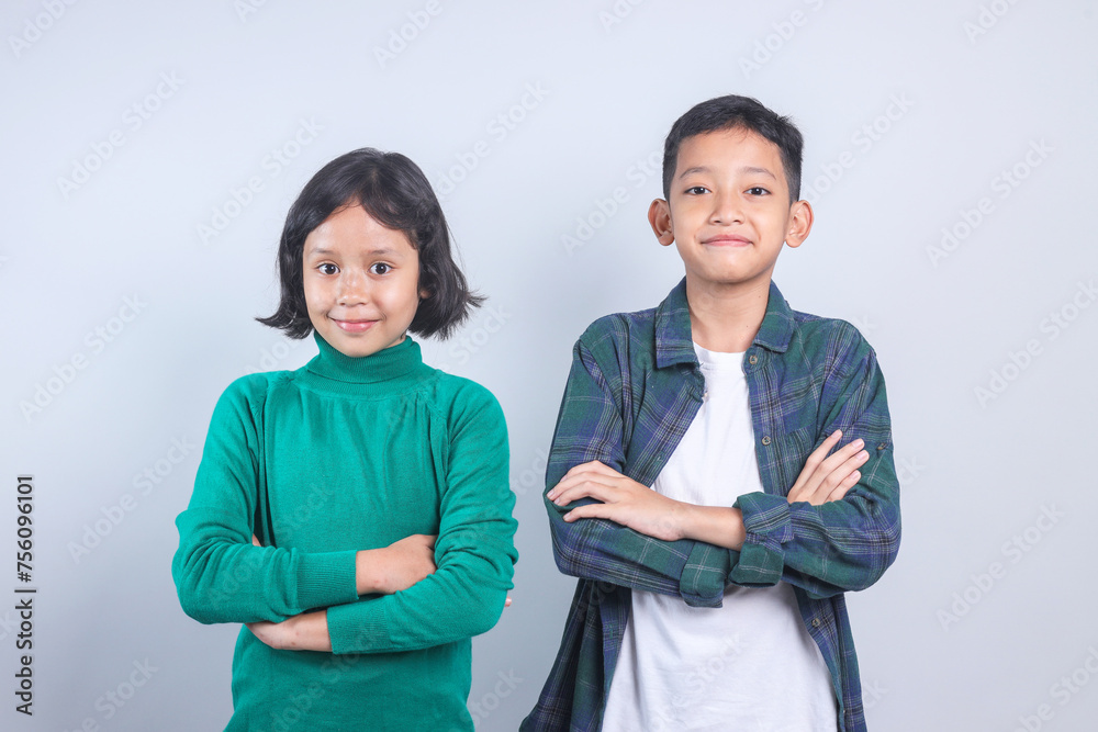 Portrait of two Asian children standing side by side on grey background Portrait of two Asian children standing side by side on grey background