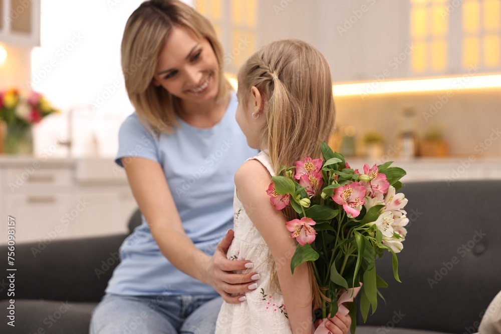 Little girl hiding bouquet of alstroemeria flowers for mom at home, selective focus. Happy Mother's Day Little girl hiding bouquet of alstroemeria flowers for mom at home, selective focus. Happy Mother's Day