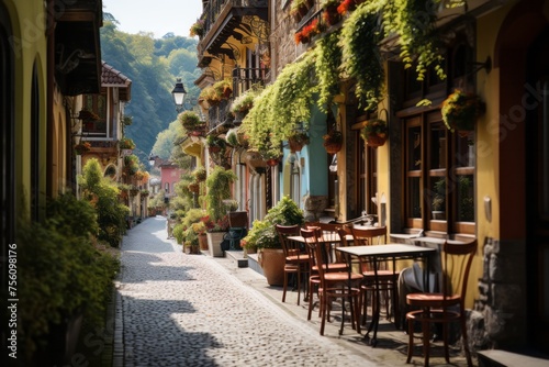 Cobblestone street lined with tables, chairs, and plants