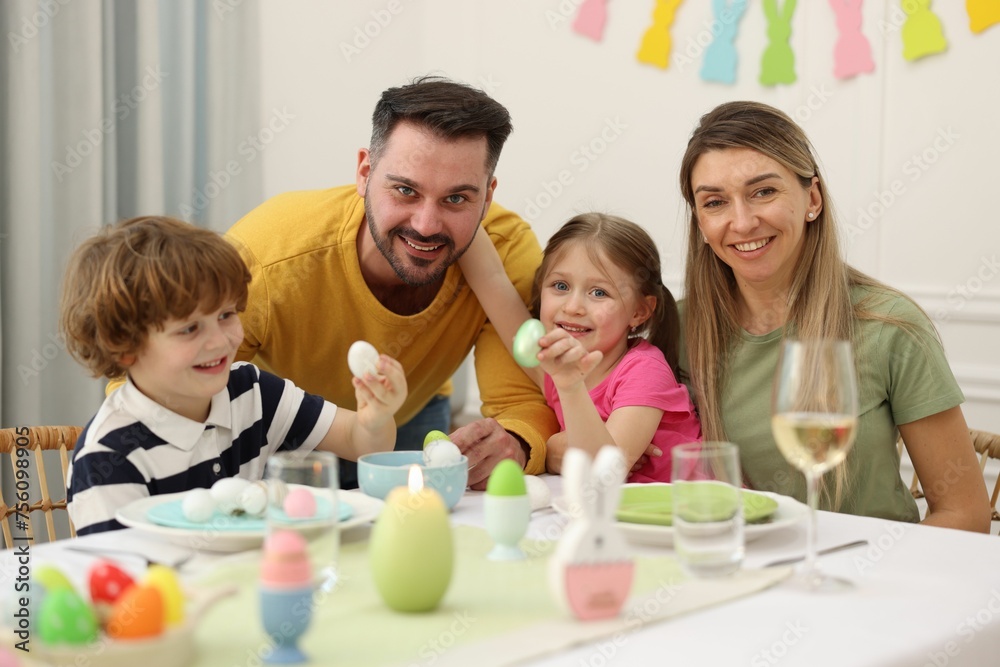 Happy family celebrating Easter at served table in room Happy family celebrating Easter at served table in room