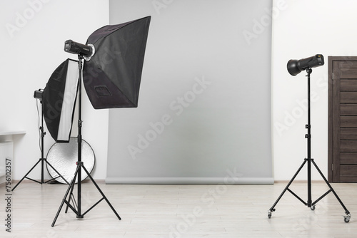 Modern light grey photo background and professional lighting equipment in studio photo