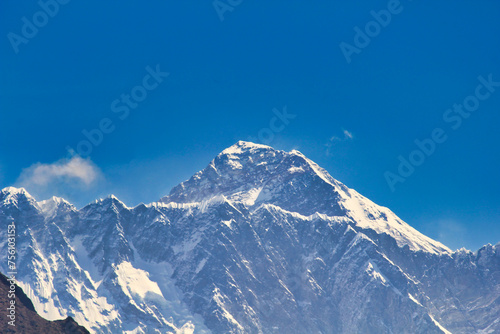 Massive West Face and summit pyramid of Mount Everest in this telephoto image taken from Namche Bazaar against a blue sky in Khumbu, Nepal photo
