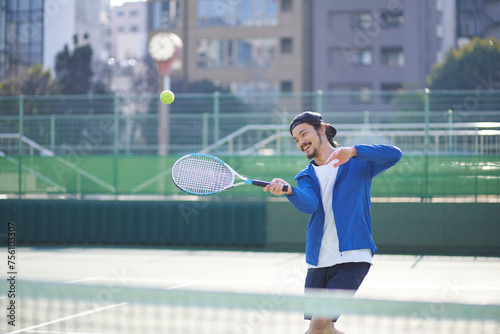 テニスボールを打ち返す男性 photo