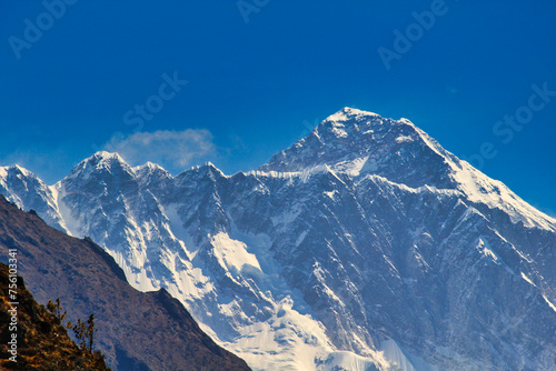 Massive West Face and summit pyramid of Mount Everest in this telephoto image taken from Namche Bazaar against a blue sky in Khumbu  Nepal