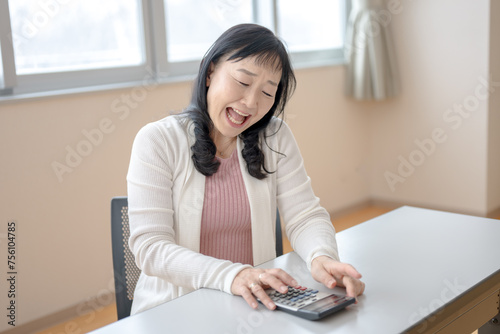 電卓を見て叫ぶ中高年女性 photo