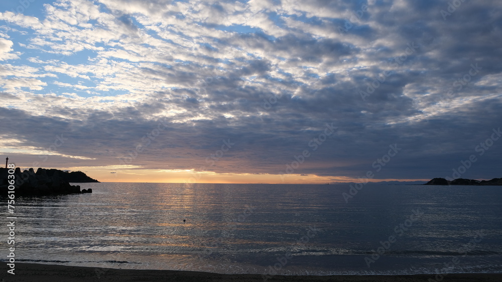 海岸から見る、太陽が海に沈む景色。