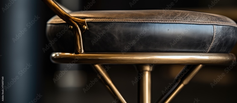 A sleek black leather bar stool with a gold metal frame, perfect for a stylish event. The contrast of leather and metal creates a modern look A sleek black leather bar stool with a gold metal frame, perfect for a stylish event. The contrast of leather and metal creates a modern look