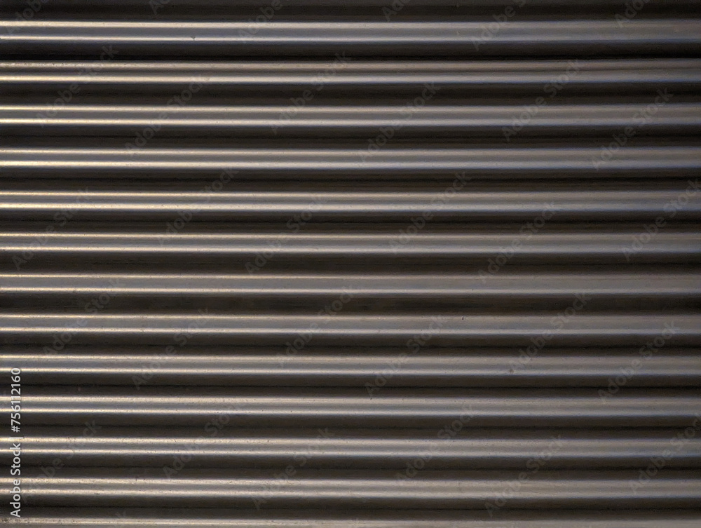Grey metal wall for construction texture or background. Gray metallic barrier with wavy stripe relief wallpaper. Metal cladding, acoustic and anti-noise industrial barrier. Grey metal wall for construction texture or background. Gray metallic barrier with wavy stripe relief wallpaper. Metal cladding, acoustic and anti-noise industrial barrier.