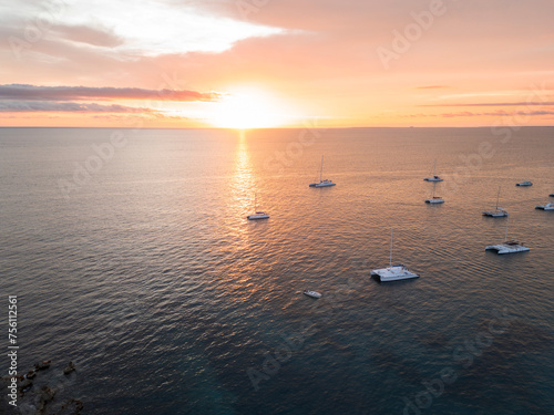 Aerial drone photo of many white yachts and boats at the calm turquoise ocean water shot at sunset hour. South destination, travel, sea navigation concept. © Elena Berd