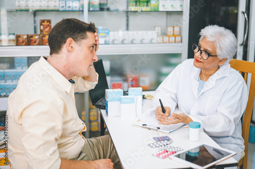 Pharmacist giving advice And advice for patients who come to buy Medicine  Drugs  Vitamins products  according to prescriptions in modern pharmacies.