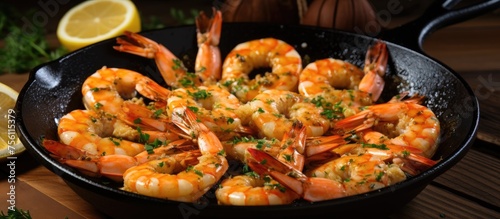 A pan filled with succulent shrimp and slices of lemon resting on a rustic wooden table. The perfect seafood dish waiting to be enjoyed