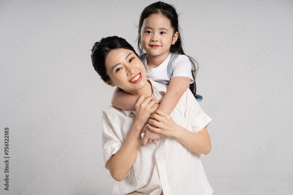Portrait of an Asian mother and daughter posing on a white background Portrait of an Asian mother and daughter posing on a white background