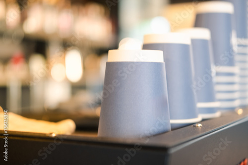 A stack of blue paper cups lies on the rack in a row