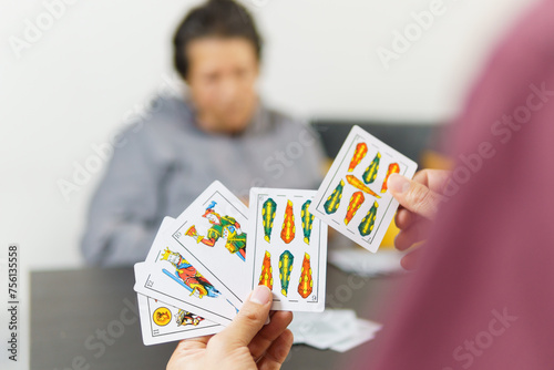 a man playing spanish cards or tute with his mom photo
