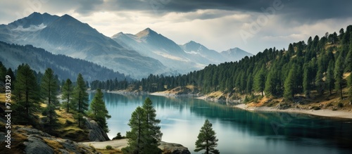 A tranquil lake lies in the heart of a forest, surrounded by towering mountains and under a sky filled with fluffy clouds, creating a stunning natural landscape