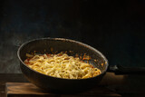 photograph of fettuccini carbonara noodles with tomato sauce garlic various seasonings in an old frying pan giving flavor to the food