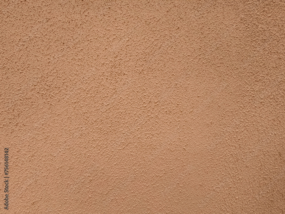 Salmon rough cement wall texture or background. Peach or beige wall with gotele effect paint.