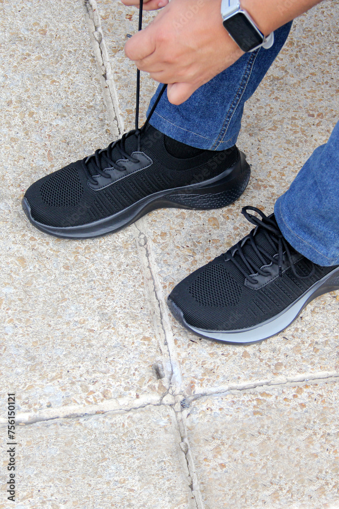Latin adult man wears black tennis shoes that serve to protect the foot from friction with a cushioning effect, reducing the effort of the muscles and tendons