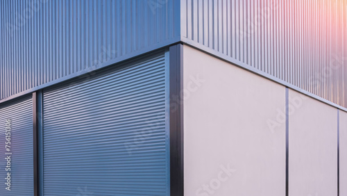 Automatic roller shutter entrance doors with gray corrugated steel and concrete wall of new modern warehouse building, Symmetric view