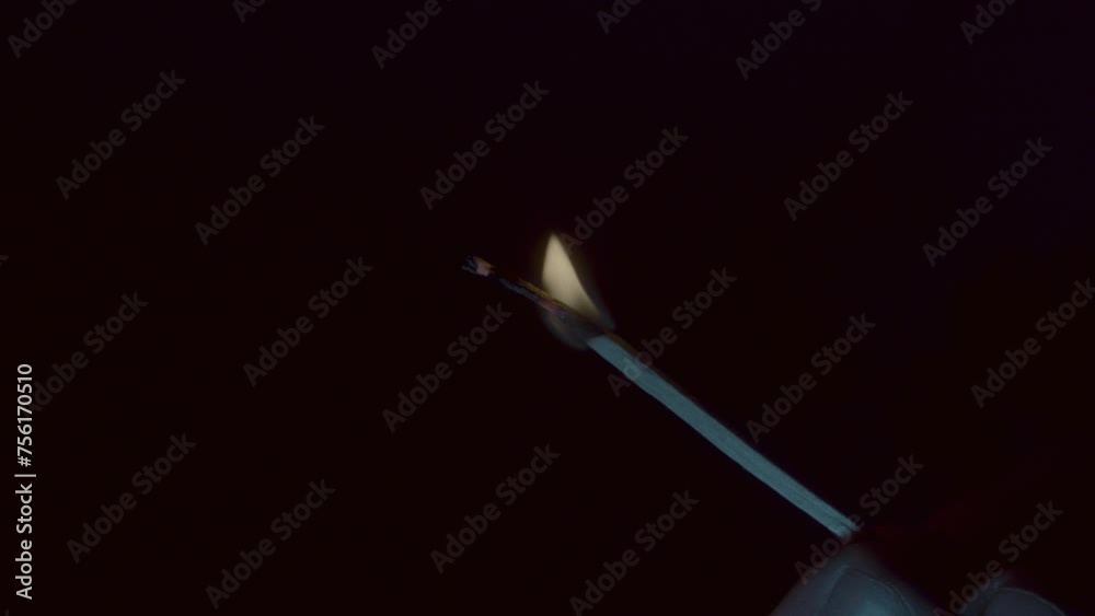 Fingers holding a burning match close up on a dark background Fingers holding a burning match close up on a dark background