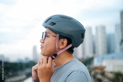 a young cyclist is wearing his helmet.