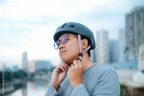 a young cyclist is wearing his helmet.