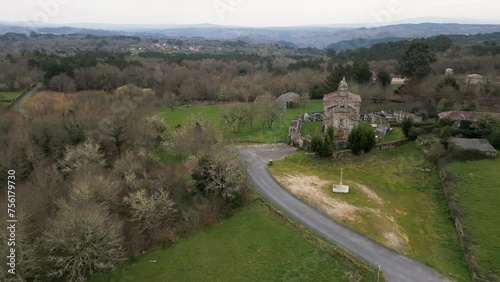 Aerial pullback over Church of santa maria de salamonde in San Amaro Spain on grassy hillside photo